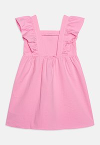 Vestido rosa con tirantes con volantes, tejido texturizado, un corsé ajustado y una falda acampanada. El material tiene una sutil textura que realza el interés visual.