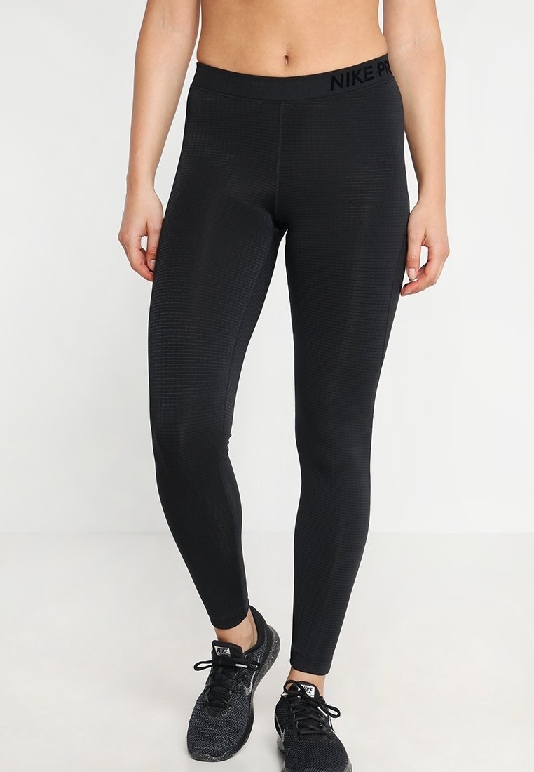 Černé sportovní legíny vyrobené z elastického materiálu s texturovaným vzorem a vysokým pasem, na kterém se nachází logo "NIKE PRO".