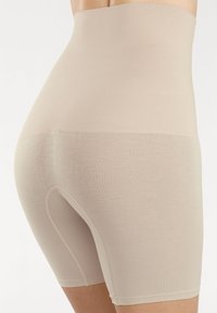 Shorts modellanti beige a vita alta realizzati in un materiale morbido, con lunghezza a metà coscia e un piccolo’apertura per comodità.
