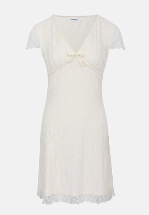 Robe courte en dentelle crème avec décolleté en V, manches courtes, taille cintrée, détail nœud sous le décolleté et ourlet festonné.