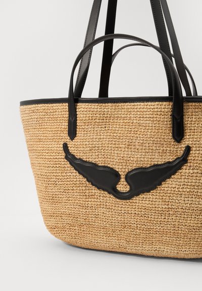 Geflochtene Strohtasche mit schwarzen Lederelementen und einem flügelähnlichen Design auf der Vorderseite; verfügt über doppelte runde Griffe.