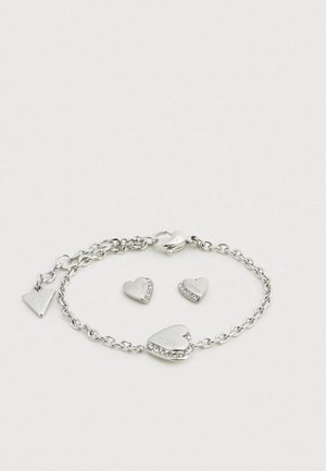Silver-tone bracelet with a chain design, featuring heart-shaped charms with engraved text and one charm adorned with rhinestones.