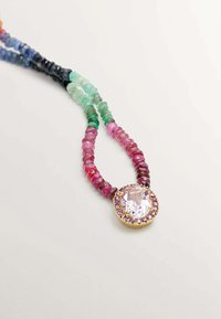 Collar de piedras preciosas multicolores con una piedra central clara rodeada por un engaste de piedras doradas y rosas. Perlas irregulares y texturizadas.