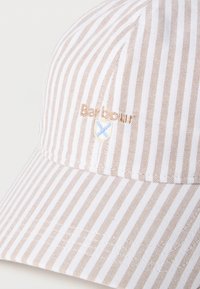 Μπεζ και λευκό ριγέ καπέλο μπέιζμπολ Barbour με κεντημένο λογότυπο με ασπίδα και μπλε σταυρό στο μπροστινό πάνελ.