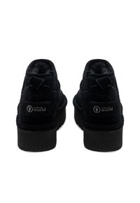Botines de ante negros con un acabado texturizado, puntera redondeada y un tacón pequeño. Presenta un parche de logo en la parte trasera y una lengüeta.