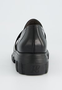 Schwarzer Leder-Schuh mit einer abgerundeten Rückseite, strukturiierter Sohle und Ausschnitt-Design an den Seiten, mit einem auffälligen Logo an der Ferse.