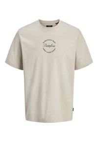 Helles beige T-Shirt mit kurzen Ärmeln aus weicher Baumwolle. Es hat einen runden Halsauschnitt und ein zentrales grafisches Textdesign mit geschwungener Schrift.