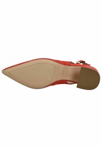 Scarpa con tacco alto in suede rosso, con punta affusolata e una sottile cinghia alla caviglia, dotata di una suola beige liscia e dettagli in hardware dorato.