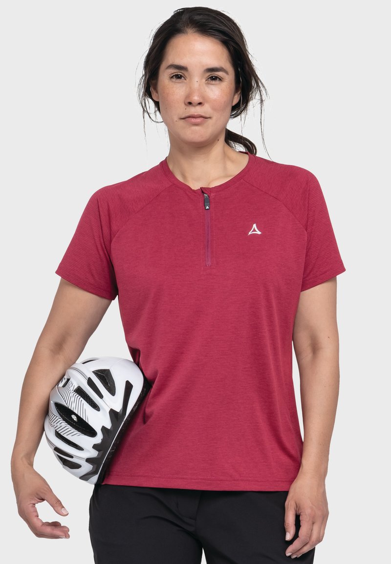 Rotes, kurzärmeliges Sporthemd mit einem Viertelreißverschluss und Raglanschnitt. Die Person hält einen weißen Fahrradhelm.