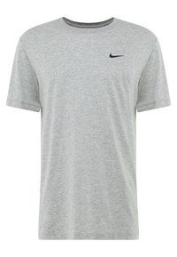 Camiseta de algodón gris con cuello redondo y mangas cortas. Presenta un pequeño logo negro de Nike en la parte izquierda del pecho.