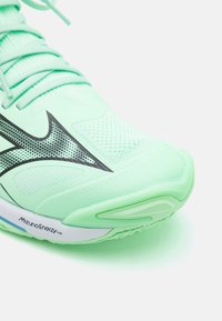 Scarpa da corsa verde chiaro con tomaia in mesh traspirante, design con accenti neri, superficie testurizzata e dotata di branding Mizuno Enerzy sulla suola.