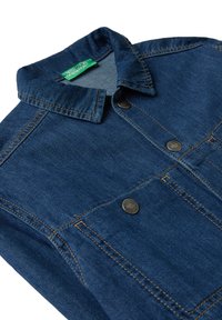 Tmavě modrá džínová bunda se hnědým prošíváním, kovovými knoflíky, předními kapsami a zelenou nálepkou United Colors of Benetton uvnitř límce.