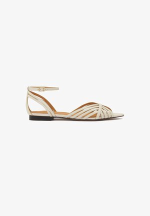 Off-white nahkast valmistatud lamedad sandaalid rihmadega, millel on mitmed horisontaalseteks rihmad ja pahkluul kinnitatav pandla, terava nina disain ja madal konts.