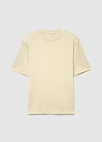 T-shirt à manches courtes avec col rond, fabriqué en coton léger. Présente une couleur beige clair unie avec une coupe décontractée et des manches légèrement retroussées.