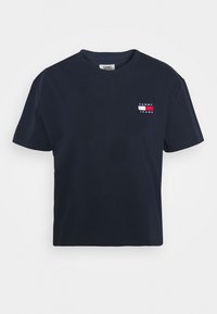 Tmavě modré tričko s krátkým rukávem a kulatým výstřihem s malou obdélníkovou nášivkou loga Tommy Jeans na levém prsu.
