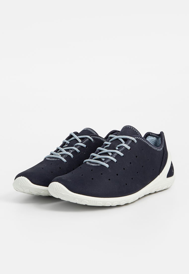 Granatowe sneakersy z perforowaną powierzchnią, jasnoniebieskimi sznurowadłami i białą gumową podeszwą. Posiadają okrągły czubek oraz wyściełany kołnierz dla większego komfortu.