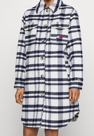 Robe-chemise longue à carreaux blancs et bleu marine avec poches poitrine à rabat et logo Tommy Jeans sur la poche gauche et au poignet.