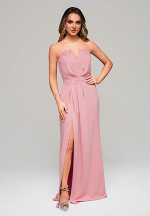 Rosa, bodenlanges Kleid mit trägerlosem Design, das über einen scharfen Ausschnitt und Falten verfügt. Ein Seitenschlitz lässt das Bein hervorschauen, kombiniert mit silbernen Riemchenheels.