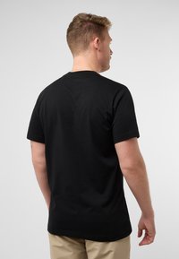 Schwarzes Baumwoll-T-Shirt mit kurzen Ärmeln, rundem Ausschnitt und glatter Textur, von hinten auf einem hellen Hintergrund präsentiert.
