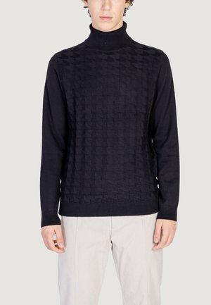 Pull en col roulé noir avec un motif géométrique texturé en relief. Les poignets et l'ourlet côtelés ajoutent du détail au design ajusté.