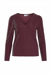 Bordeaux langermet topp med dyp V-hals, laget av et teksturert, glitrende stoff. Har samlet skuldre for ekstra detaljer.