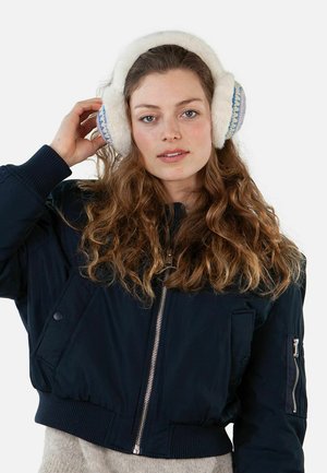 White fleece-lined earmuffs with blue accent stitching, worn by a person with wavy hair, paired with a black bomber jacket.