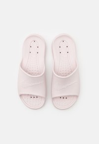 Sandales en caoutchouc rose avec un logo Nike surélevé orné de strass, semelle intérieure texturée et design à enfiler.