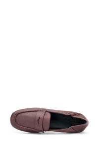 Zapato mocasín de cuero marrón con textura suave, diseño sin cordones y detalles de costura superior. Presenta una punta redondeada y acentos mínimos.