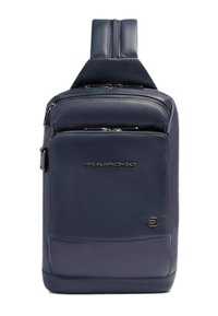 Mochila de cuero azul marino con dos compartimentos con cremallera, textura lisa y asa superior. Cuenta con un logotipo y un diseño rectangular elegante.