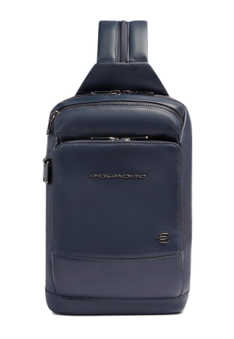 Mochila de cuero azul marino con dos compartimentos con cremallera, textura lisa y asa superior. Cuenta con un logotipo y un diseño rectangular elegante.