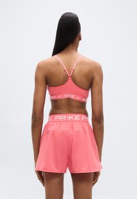 Ροζ αθλητικό σουτιέν με ρυθμιζόμενους ιμάντες και λεία υφή, σετ με ταιριαστά ροζ σορτς με φαρδιά μέση και λογότυπο "PRIKE".