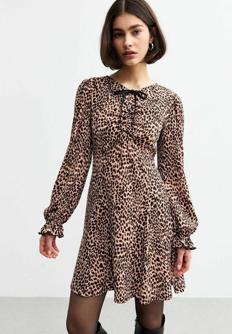 Leopardenmusterkleid in Hellrosa und Schwarz, lange Ärmel mit gerafften Manschetten, gebundenem Ausschnitt, fließende Mini-Silhouette, weicher Stoff.
