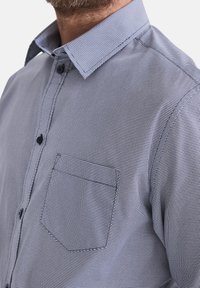 Herrenhemd mit Knopfleiste in Hellblau mit einem Mikro-Muster, ausgestattet mit einer Brusttasche, klassischem Kragen und strukturierter Stofftextur.