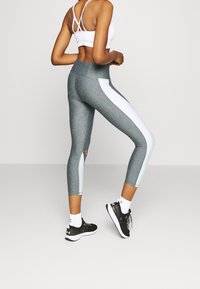 Legginsy sportowe z wysokim stanem w kolorze heather gray z białymi panelami bocznymi. Posiadają akcent logo oraz dopasowany krój dla wygody i elastyczności.