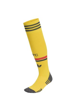 Chaussette jaune haute jusqu'au genou avec des rayures noires en haut, des bandes rouges et noires au milieu, un talon et un bout noirs, et un logo noir près de la cheville.