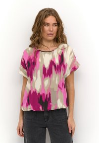 Loose-fitting blouse in a flowing fabric, featuring a bold pink, gray, and black abstract pattern. Round neckline and short sleeves.