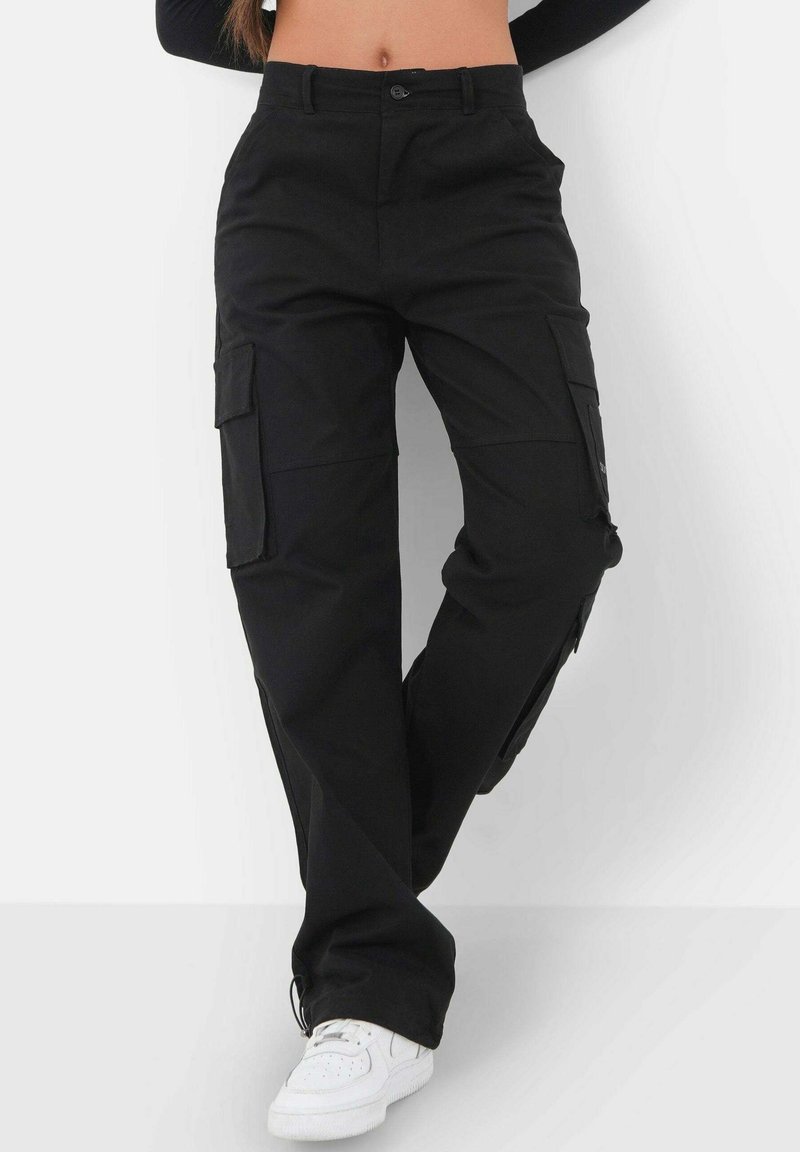 Pantalons cargo noirs en tissu durable, dotés de poches latérales, d'un design à jambe droite et de poignets élastiques aux chevilles.