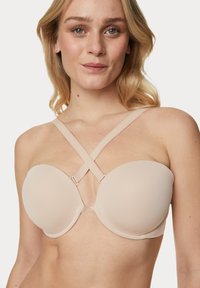 Gevoerde strapless bh in nude met een gladde afwerking, voorzien van kruislings gespen en een U-vormige balein voor ondersteuning.