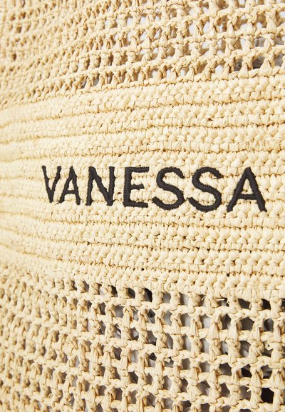 Kudottu olki materiaali luonnollisen beigen värissä, jossa on musta brodeerattu "VANESSA" -logo ja tekstuurinen avoin kudontakuosi.