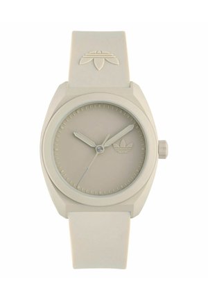 Beige Adidas-Armbanduhr mit rundem Zifferblatt, minimalen Stundenmarkierungen, drei Zeigern und Adidas-Logo auf Zifferblatt und Armband.