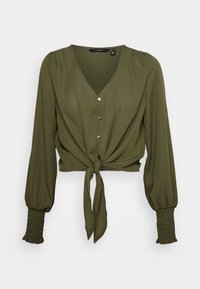 Blusa verde oliva con scollatura a V, chiusura a bottoni e dettaglio con fiocco davanti. Presenta maniche lunghe a palloncino con polsini arricciati. Texture liscia.
