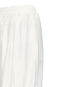 Biely materiál s elastickým pásom, ozdobený tenkými zvislými pruhmi v modrej, oranžovej a fialovej farbe, pripomínajúci pyžamové nohavice alebo bežné oblečenie.