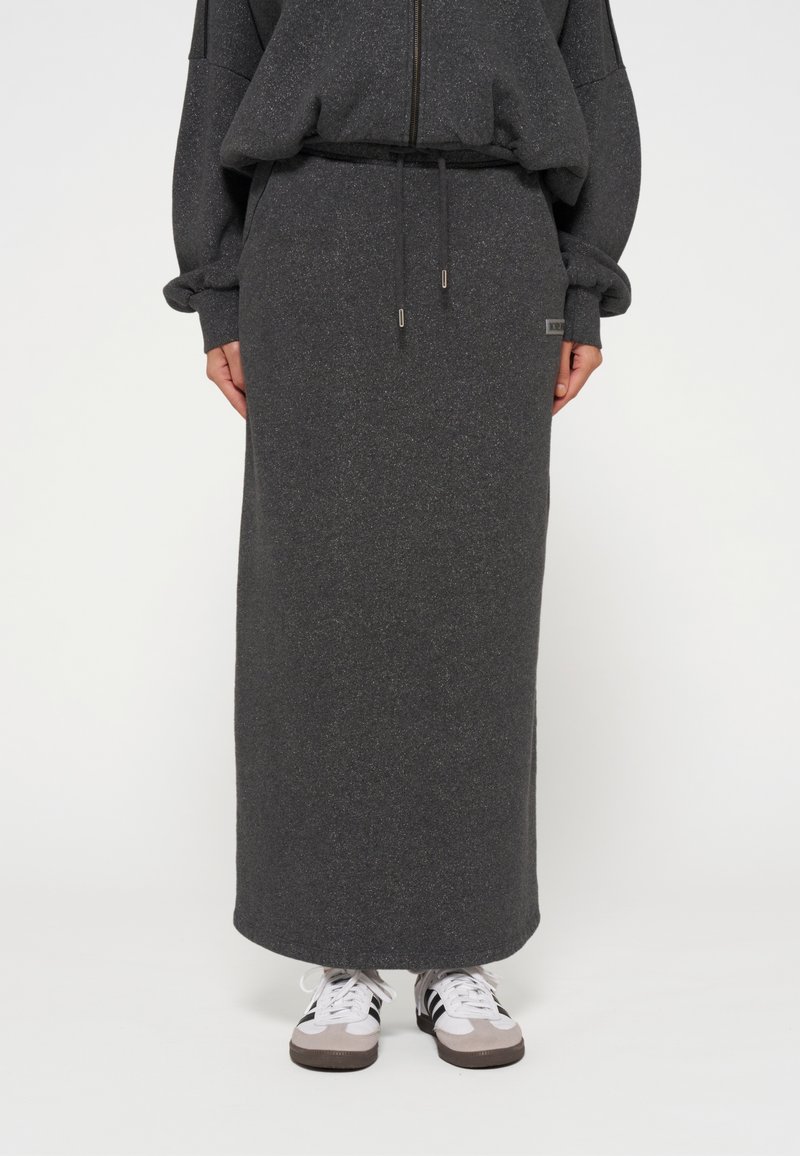 Dunkelgraßer langer Rock aus weichem, strukturiertem Stoff mit einem elastischen Bund und Kordelzug, kombiniert mit lässigen Sneakers.