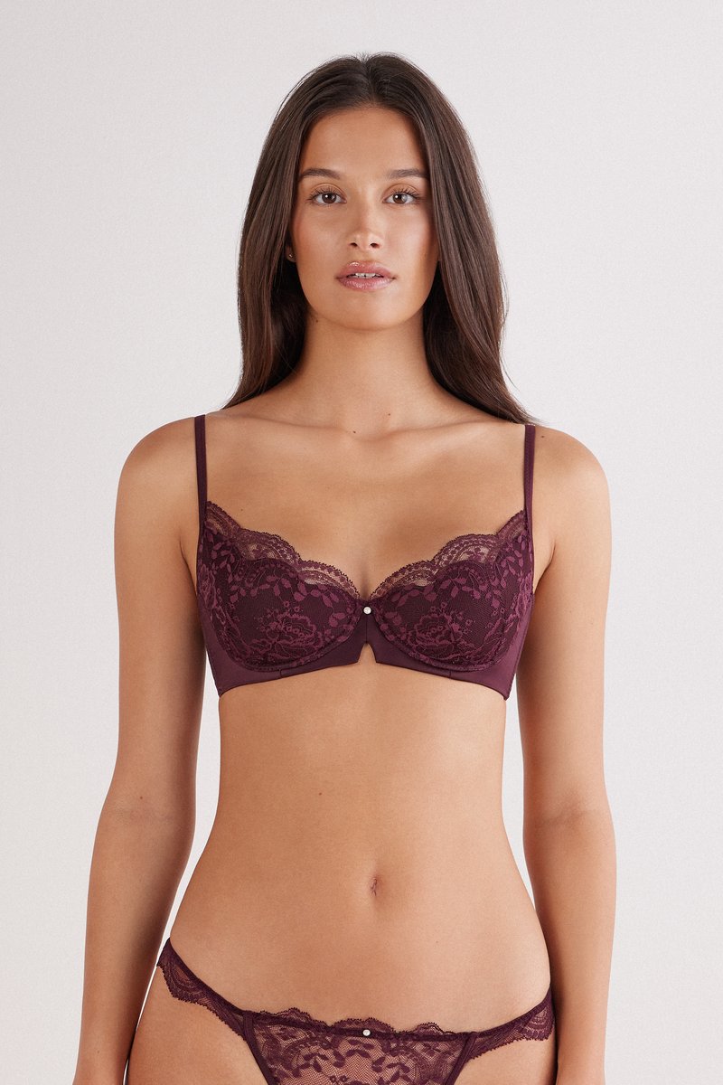 Burgundy spets-balkong-bh med vågiga kanter, justerbara band och liten detalj i mitten. Har blommönster och en slät yta.
