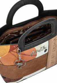 Sac à main multicolore avec une poignée noire, présentant un mélange de textures : cuir lisse, à motifs et gaufré. Charme en métal attaché.