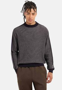 Maglione lavorato a maglia di colore grigio scuro con un motivo testurizzato, caratterizzato da polsini e orlo a coste neri, con strisce laterali a contrasto.