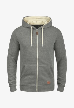 Grå zip-up hættetrøje lavet af blødt stof med en lysfavet for, frontlommer og snoretræk, med en lille læderdetalje.