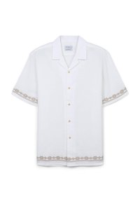 Camicia bianca a maniche corte realizzata in tessuto leggero, con bottoni dorati e un intricato ricamo geometrico marrone lungo le maniche e l'orlo.