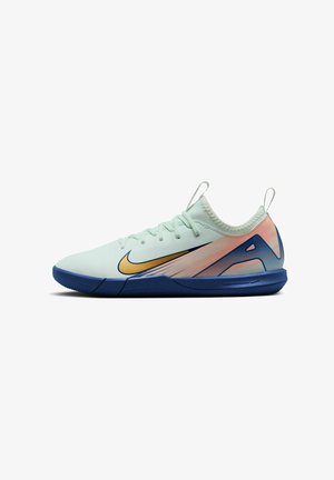 Chaussure de sport Nike avec une tige vert menthe clair, un swoosh doré, une semelle extérieure bleue et des accents de design multicolores. Caractérisée par un matériau texturé et respirant.