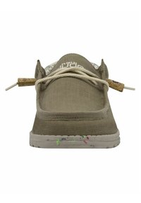 Zapato de lona de color marrón claro con un upper texturizado, cordones blancos y acentos de corcho. La suela tiene manchas de pintura coloridas. Diseño plano, punta redonda.